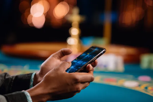 A player using their smartphone during a festive local event, representing 1XBEF’s fully mobile-friendly casino.